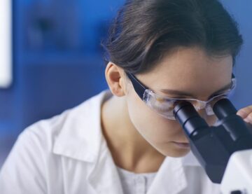 Researcher looking into microscope