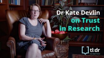 Dr Kate Devlin sits in a chair in the library
